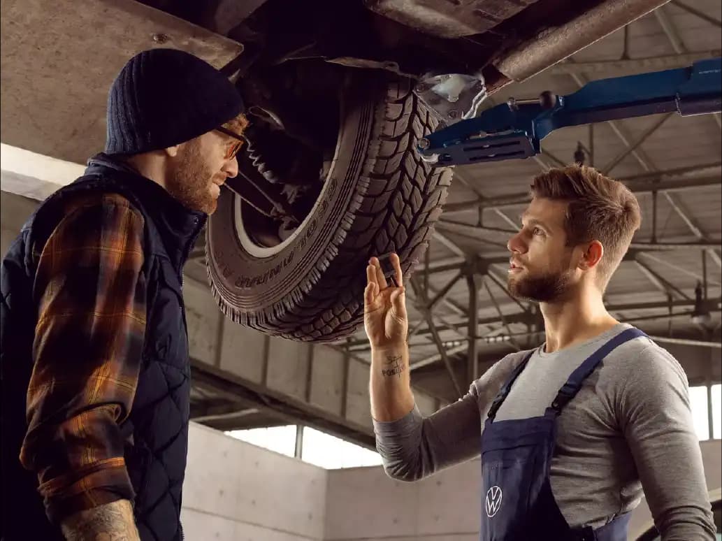 Nutzfahrzeug-Servicemitarbeiter berät Kunden vor einem Camper – professioneller Kundenservice und Beratung im Wohnmobil- und Camper-Servicebereich